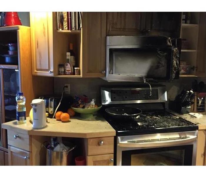 Kitchen stove and area damaged by cooking fire