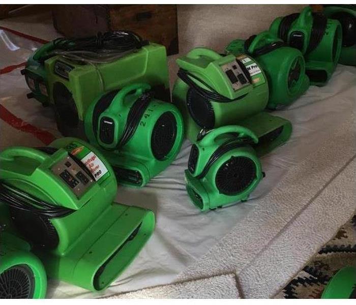 several air movers in a carpeted hallway